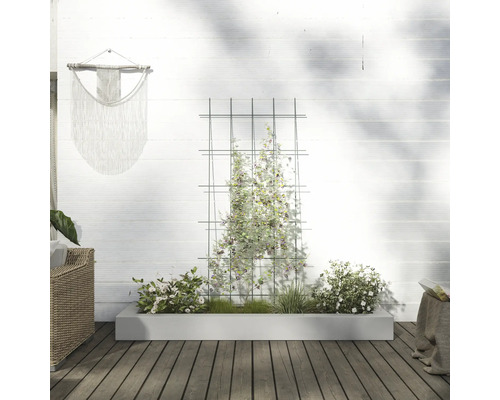 Trädgård med spaljé, planterad blomlåda och väggdekoration