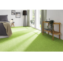Modernt sovrum med grön heltäckningsmatta, säng, lampa och dekoration