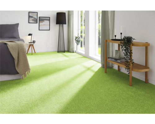 Modernt sovrum med grön heltäckningsmatta, säng, lampa och dekoration