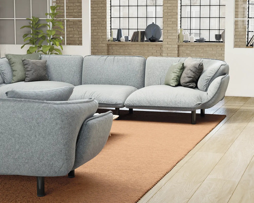 Vardagsrum med grå hörnsoffa, fåtölj och matta