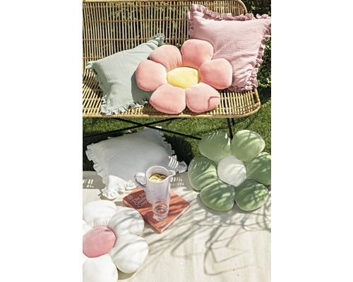 Scen med dekorativa kuddar i olika former på en bänk och en filt