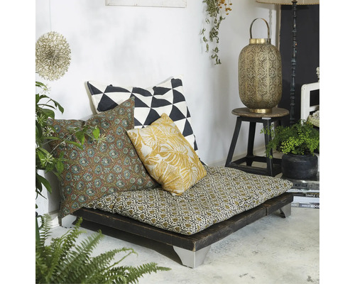 Mysig läshörna med golvkudde och diverse prydnadskuddar på en låg träram.