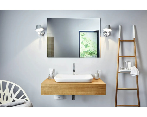 Modernt badrum med tvättställ, spegel och handdukstege