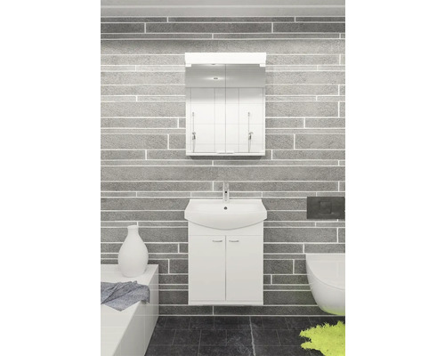 Badrum med tvättställsskåp, spegelskåp och toalett mot en grå stenvägg