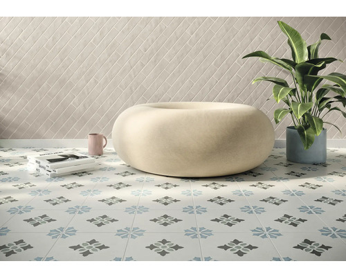 Ljust rum med dekorerade golvplattor, sittpuff, krukväxt och väggplattor