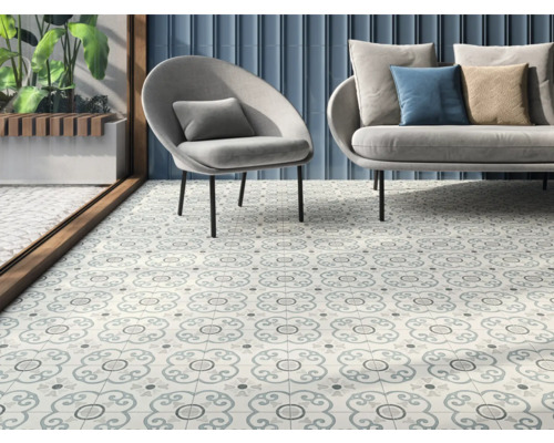 Interiör med dekorerade golvplattor, fåtölj och soffa.