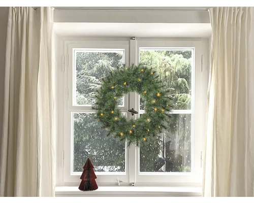 Juldekoration med fönster, gardiner, julkrans med belysning och liten julgran