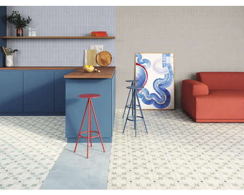 Vardagsrum med köksdel, sittplatser och blommönstrat golv