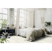 Ljust sovrum med himmelssäng, växter och byrå