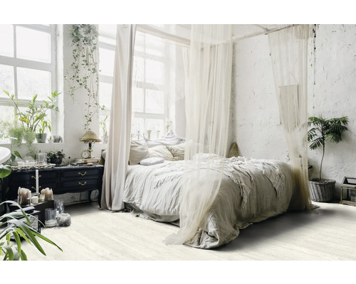 Ljust sovrum med himmelssäng, växter och byrå