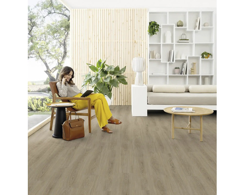 Vardagsrum med trägolv och en kvinna som sitter på en stol