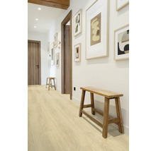 Hall med trägolv, träbänkar och inramade bilder på väggen