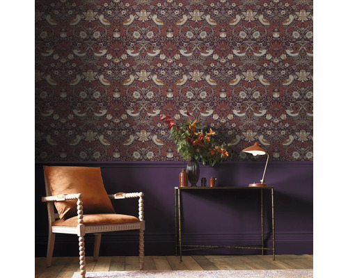 Dekorativt rum med mönstrad tapet, fåtölj och bord