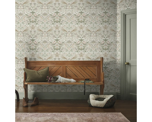 Dekorativ hall med en träbänk mot en blommig tapet.