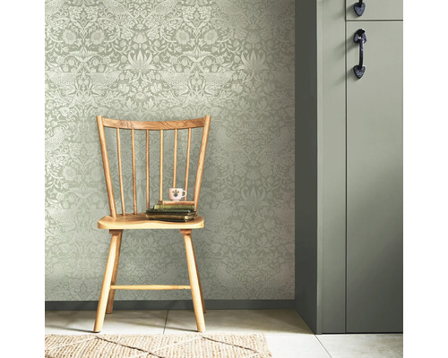 Miljöbild med blommig tapet, trästol och dörr