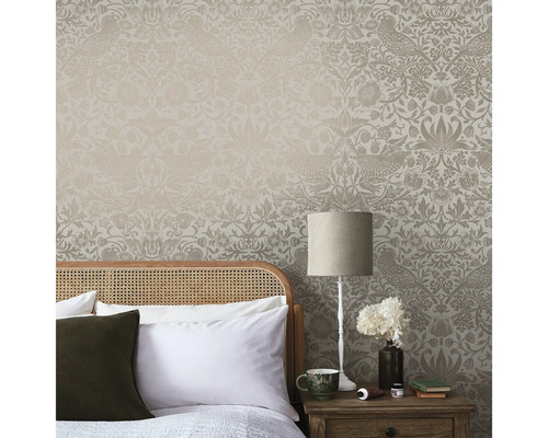 Sovrumsscen med mönstrad tapet, säng och sänglampa