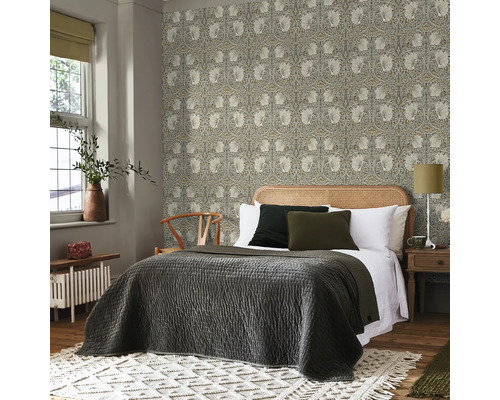 Sovrum med blommönstrad tapet, säng och nattduksbord