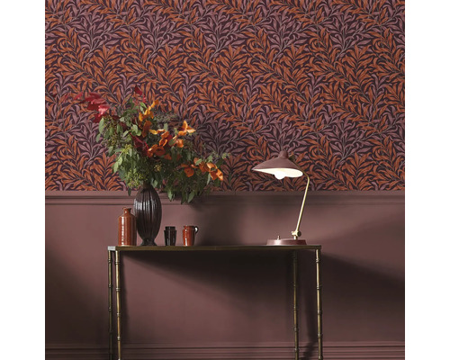 Dekorativt rum med blommig tapet, bord och lampa