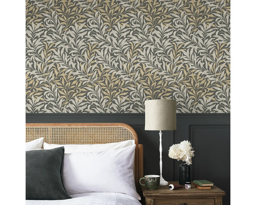 Sovrum med blommig tapet, säng och sänglampa