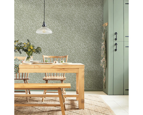 Matsal med träbord, stolar, bänk, hänglampa, blomvas och blommig tapet