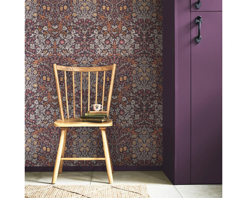 Dekorativt rum med blommönstrad tapet, trästol och lila skåp