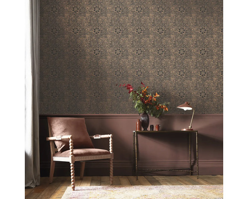 Dekorativt rum med mönstrad tapet, stol, bord och lampa