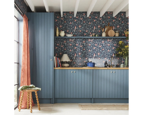 Kök med blå skåp, blommig tapet och trädetaljer för en mysig känsla