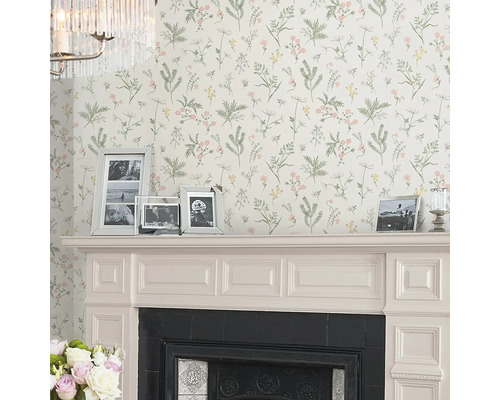 Vardagsrum med blommig tapet, öppen spis och fotoramar