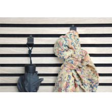 Väggpanel med krokar med ett paraply och en halsduk hängande på dem