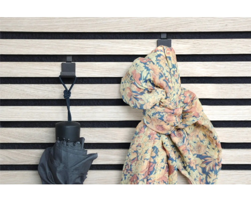 Väggpanel med krokar med ett paraply och en halsduk hängande på dem