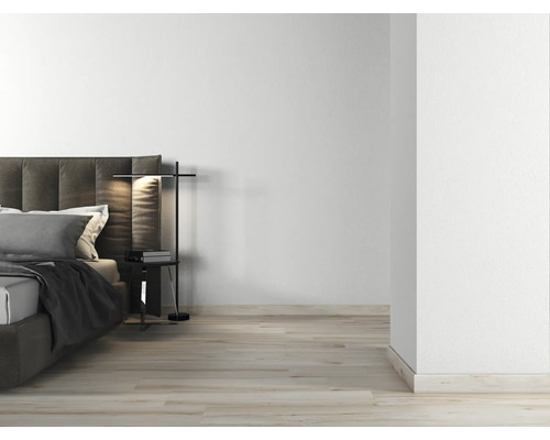 Ljust sovrum med dubbelsäng, sänglampa och trägolv