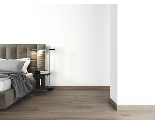 Sovrum med säng, sängbord och golvlampa