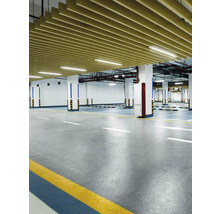 Interiörbild av ett garage med betonggolv, pelare och takbeklädnad.