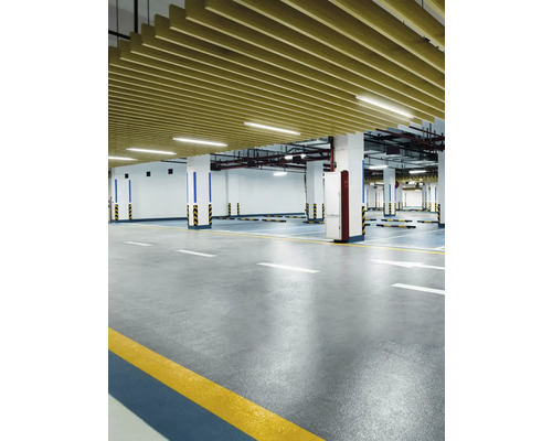 Interiörbild av ett garage med betonggolv, pelare och takbeklädnad.