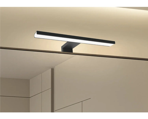 Badrum med spegel och monterad lampa