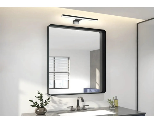 Modernt badrum med spegel, handfat och lampa