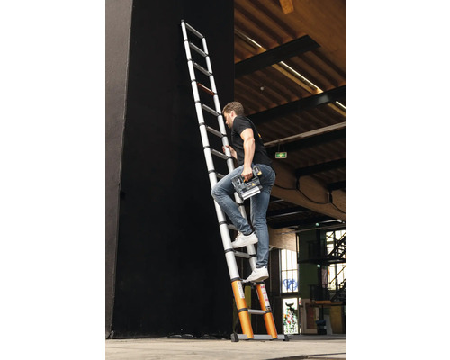 Man klättrar på en teleskopisk stege med ett elverktyg i handen.