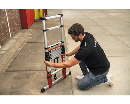 Man som fäller ihop en teleskopisk aluminiumstege