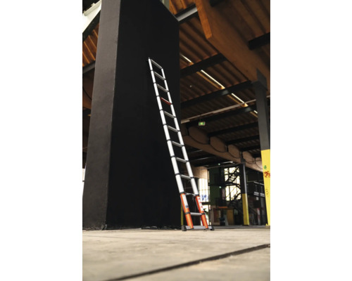 Teleskopstege lutad mot en svart pelare i en byggnad