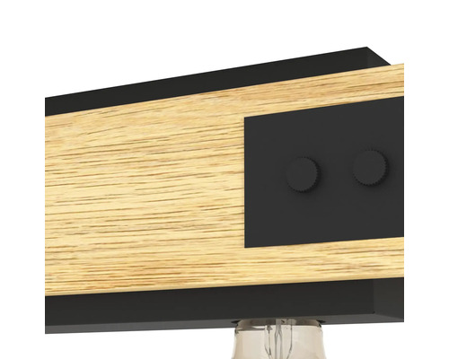 Närbild av en taklampa i trä med metalldetaljer