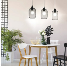 Matsal med matbord, stolar och tre svarta hänglampor