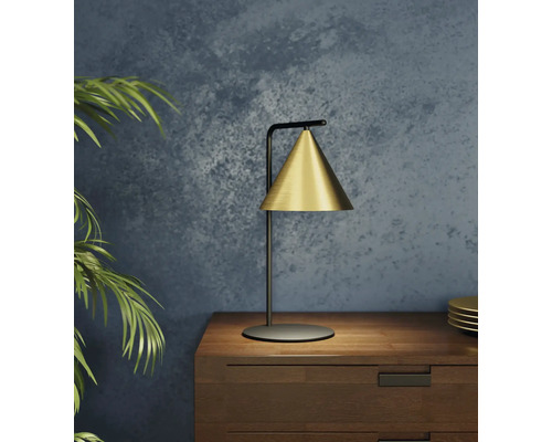 Guldfärgad bordslampa på ett sängbord