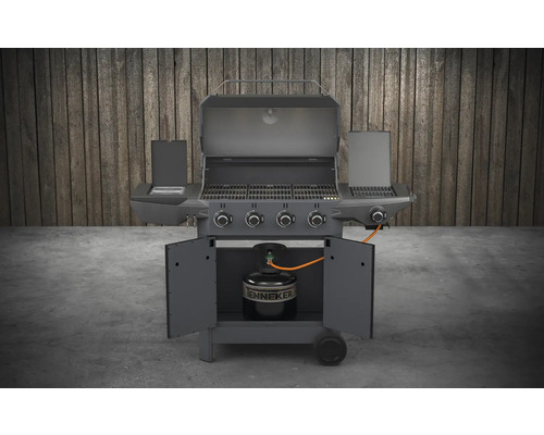 Gasolgrill med öppet lock, sidobord och en gasflaska i underskåpet