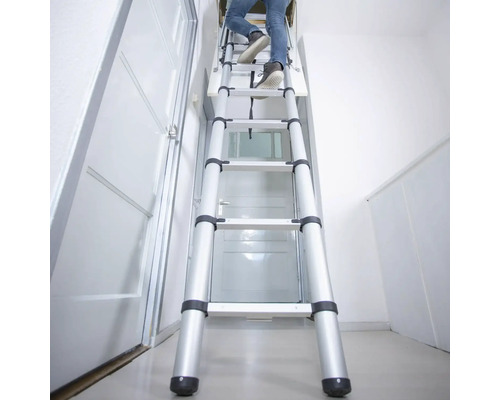 Person som klättrar på en utdragbar vindstrappa av aluminium i ett hus