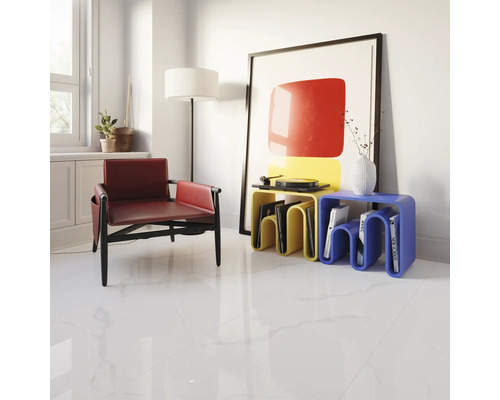 Ljust vardagsrum med fåtölj, sidobord och konstverk