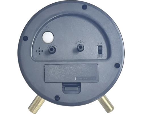 Baksida av en analog väckarklocka med batterifack och reglage