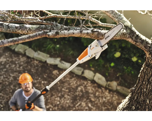 En person använder en Stihl stångsåg för att såga en gren.
