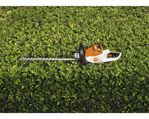 STIHL batteridriven häcksax framför en grön häck