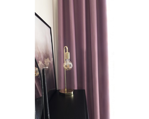 Dekorativa gardiner, en lampa och en tavla på ett skåp