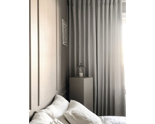 Sovrum med säng, gardiner och nattduksbord